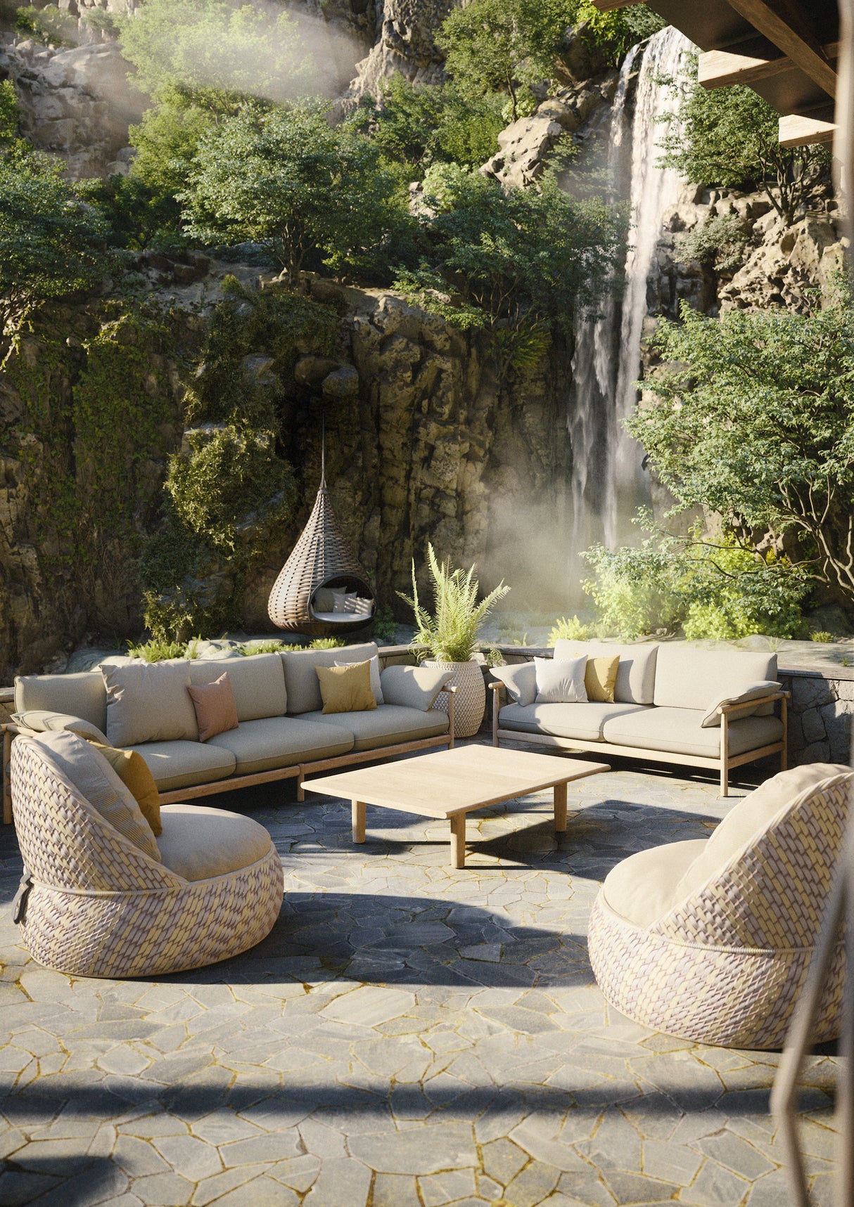 Outdoor-Sitzlandschaft mit DEDON DALA Sesseln und Sofa-Gruppe auf Natursteinboden vor einem Wasserfall