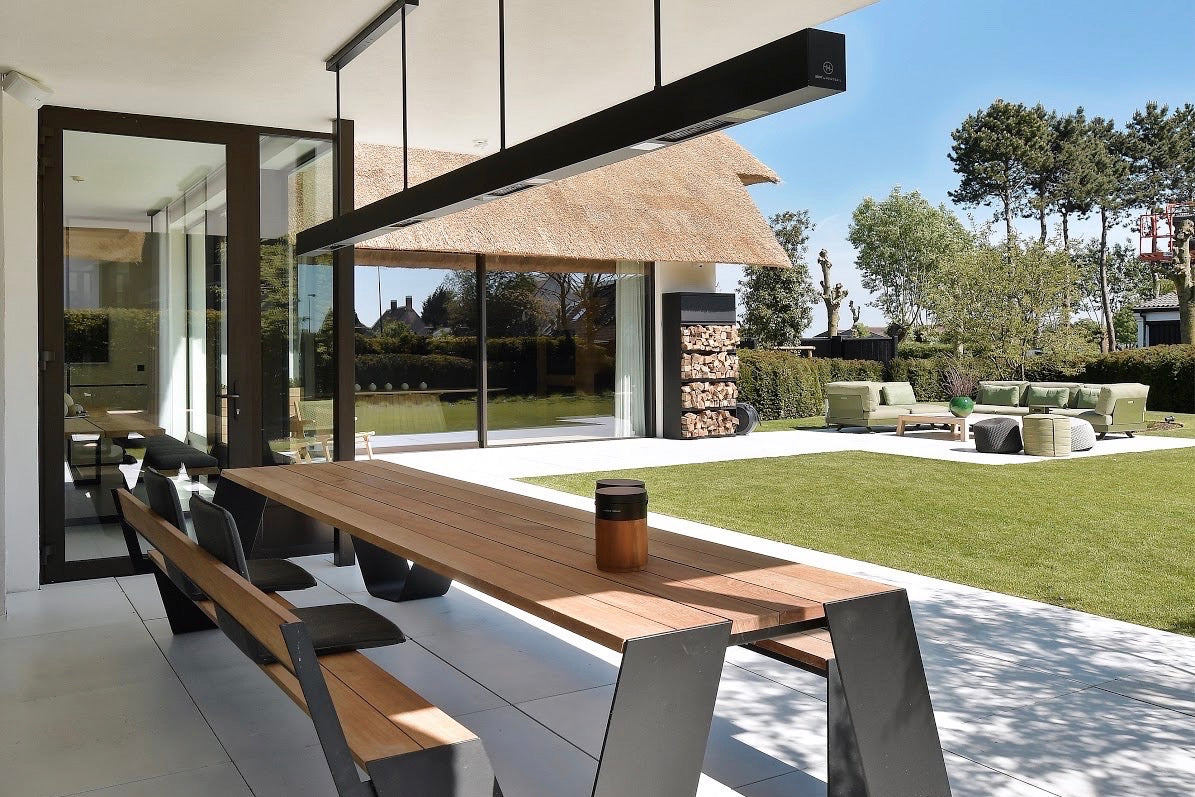 heatsail_beem_heizstrahler_an_der_decke_eier_ueberdachten_privaten_terrasse_befestigt_darunter_eine_moderne_sitzgruppe_mit_tisch_und_bank