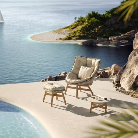 dedon_mbrace_loungesessel_mit_fusshocker_und_beistelltisch_am_poolrand_vor_meerblick_auf_felskulisse_erhaeltlich_im_onlineshop_henrik-bosse.de